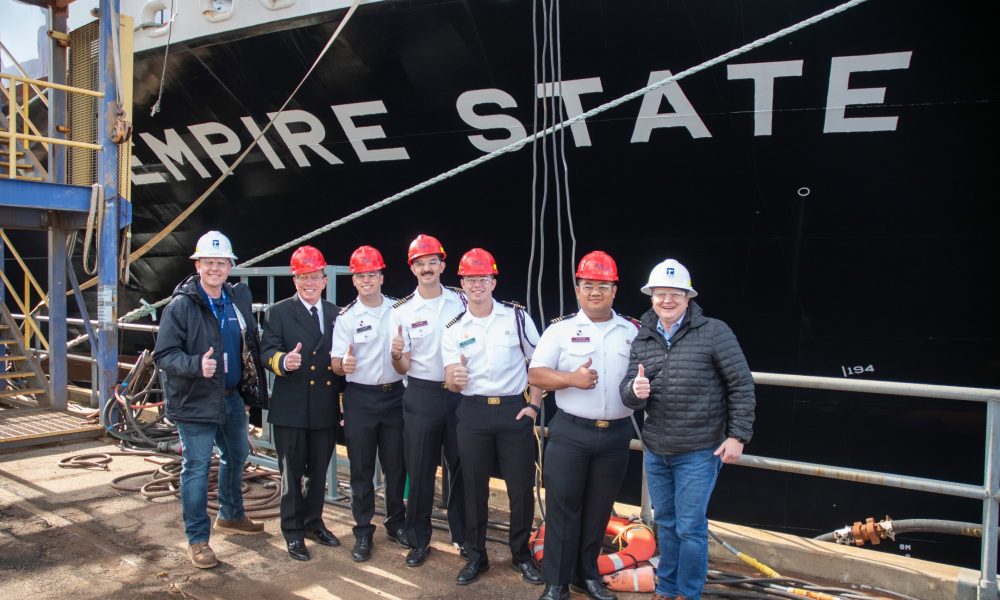 EMPIRE STATE ship with crew members giving thumbs up on dock.